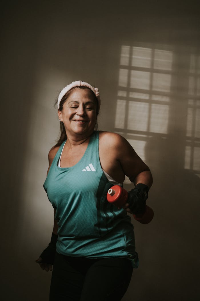 Senior woman in workout gear exercising with dumbbell, capturing a healthy lifestyle moment.